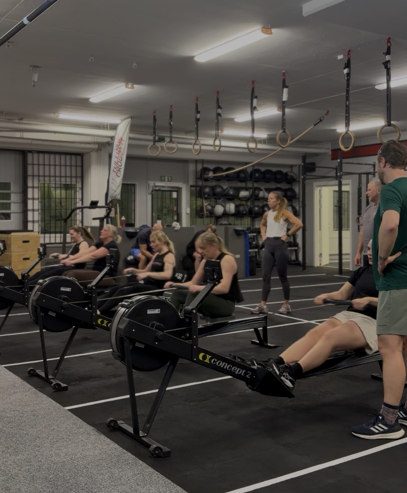 Medlemmar roddar på roddmaskiner under ett grupppass i gymmet