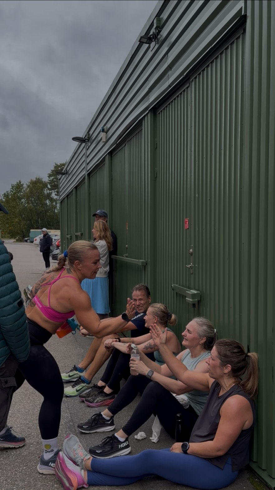 Medlemmar hejjar och tar high five utanför gymmet efter ett pass